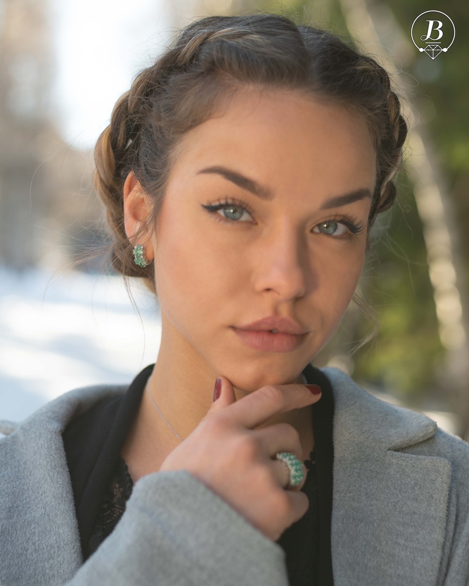 Exquisite ladies' earrings with English fastening and spectacular craftsmanship of delicate rhodium silver, intertwined with fine and numerous natural emerald stones, combined with sparkling zircons. In a charming set with matching necklace and ring.