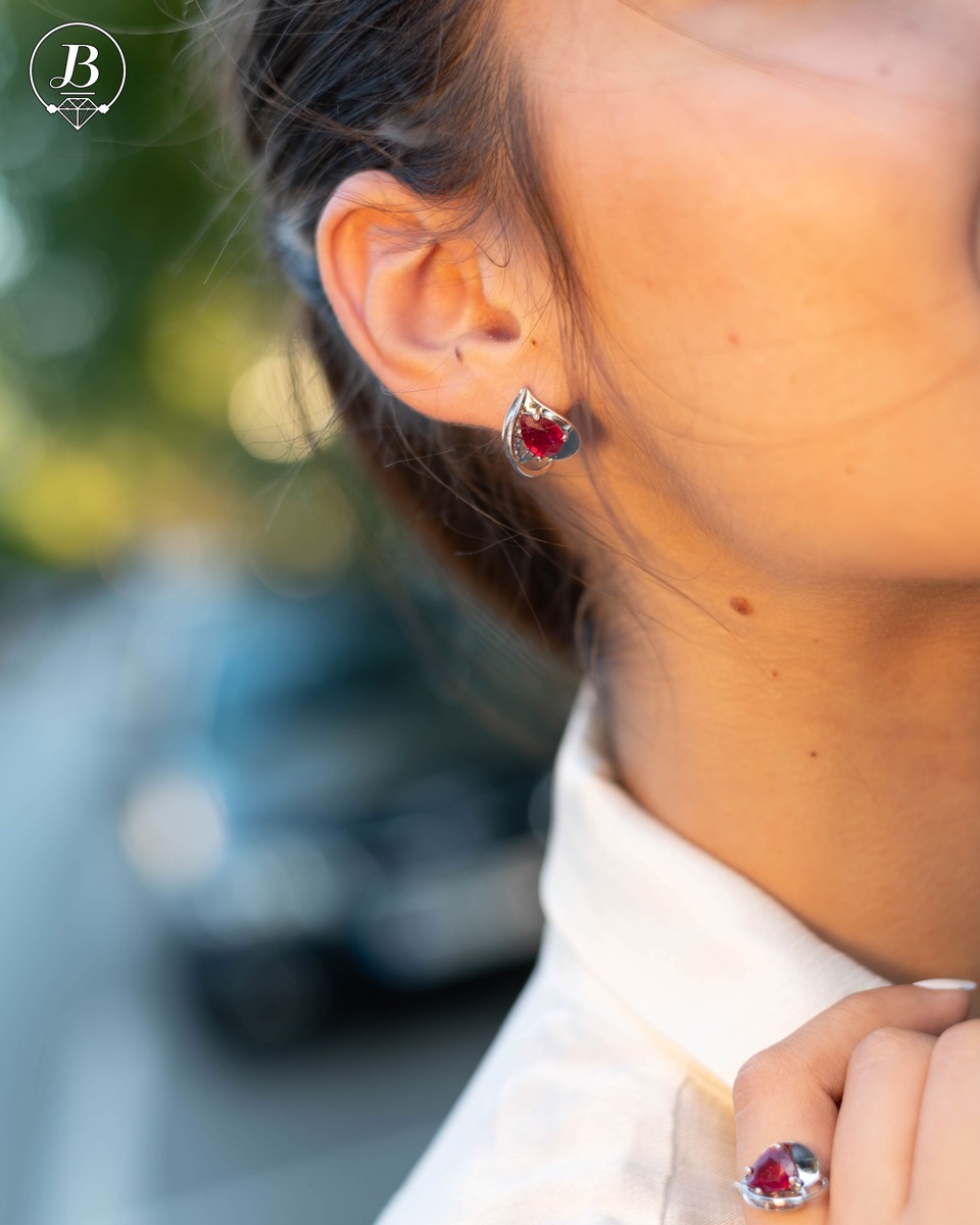 Sophisticated women's earrings with English clasp and exquisite craftsmanship with precision to detail, interweaving beautiful rhodium silver with a delicate natural ruby ​​stone in a charming teardrop shape. In an exclusive ring and pendant set.