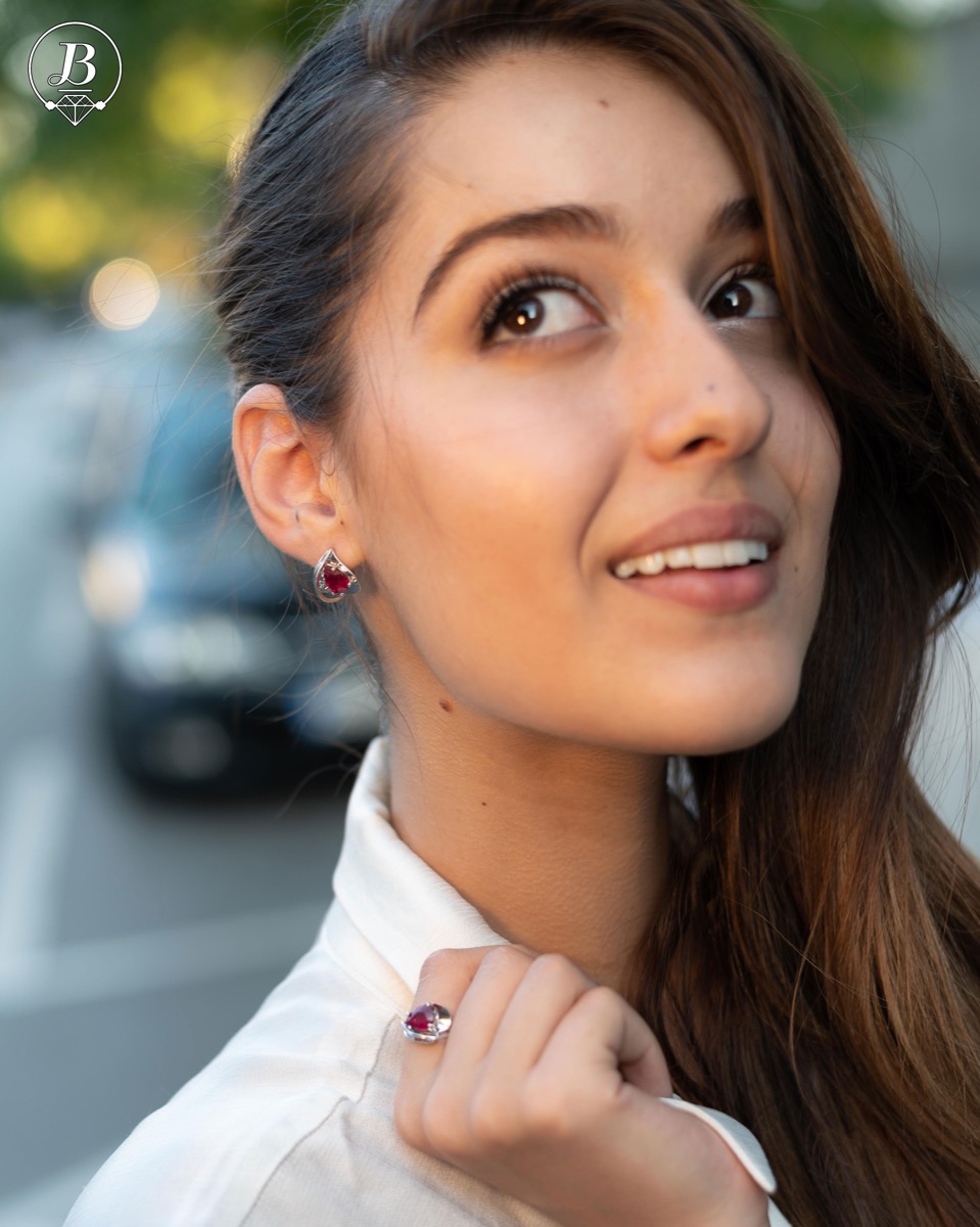 Sophisticated women's earrings with English clasp and exquisite craftsmanship with precision to detail, interweaving beautiful rhodium silver with a delicate natural ruby ​​stone in a charming teardrop shape. In an exclusive ring and pendant set.