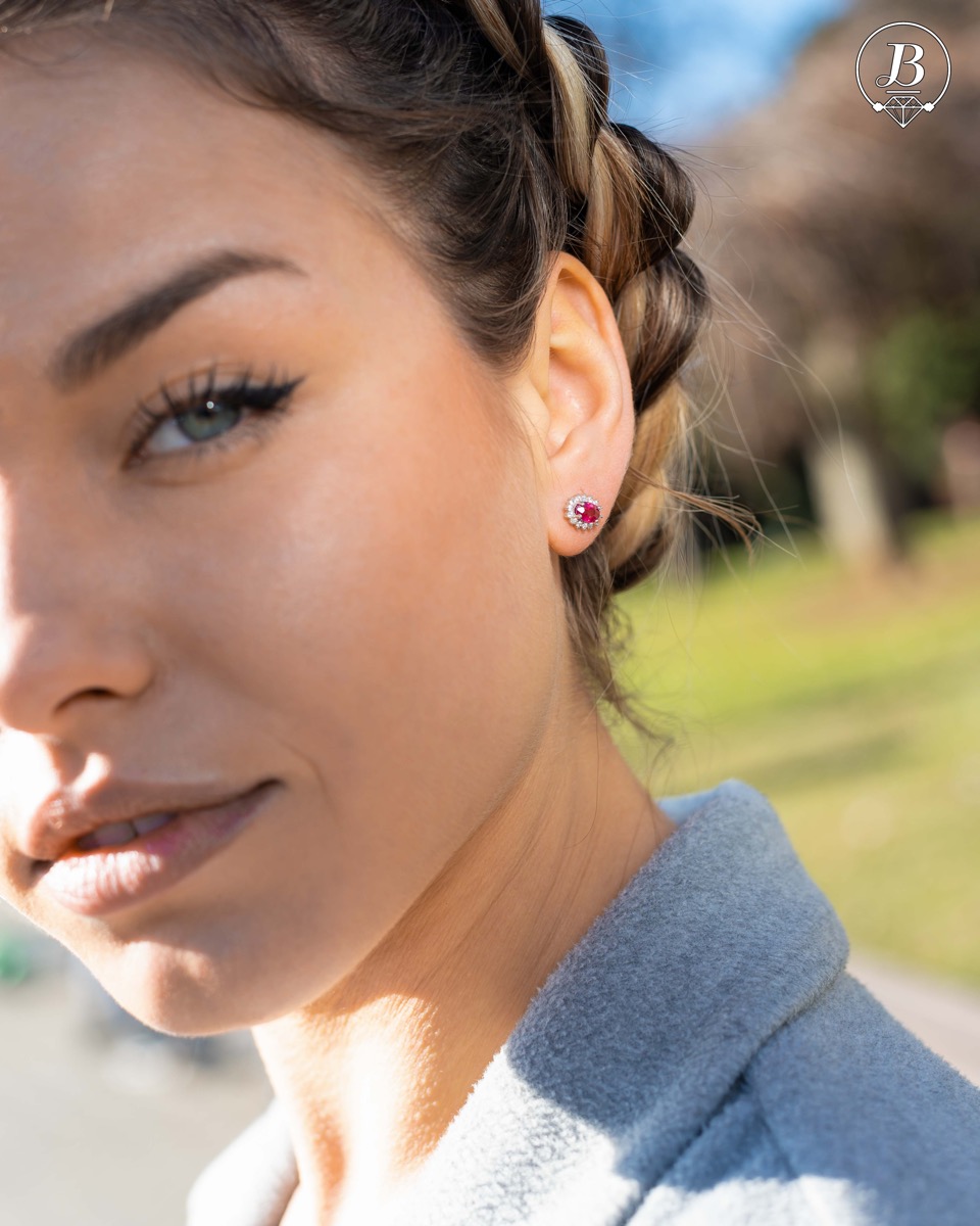 Delicate and radiant women's stud earrings with exquisite workmanship combining a unique natural ruby, surrounded by sparkling zircons, with rhodium-plated silver. They can be combined with a ring, necklace and bracelet of the same model.