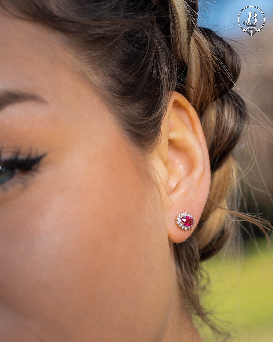 Delicate and radiant women's stud earrings with exquisite workmanship combining a unique natural ruby, surrounded by sparkling zircons, with rhodium-plated silver. They can be combined with a ring, necklace and bracelet of the same model.