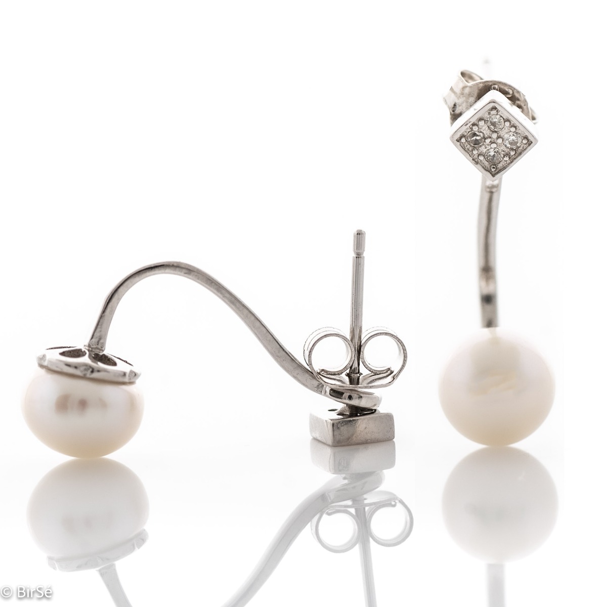 A beautiful model of women's earrings, entirely made of fine rhodium silver, with a comfortable and secure pin fastening. Delicate, sparkling zircons adorn the earpiece, while a fine pearl elegantly protrudes below. Charming and suitable for any occasion.