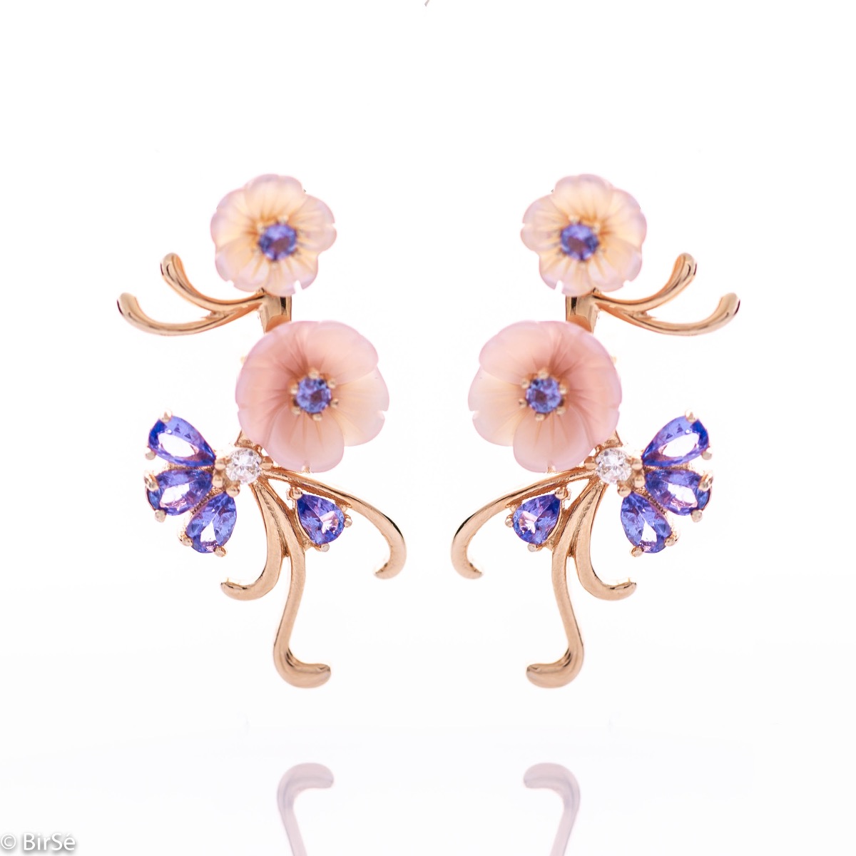 Exquisite dangle earrings with exquisite craftsmanship and delicate curves of rose rhodium silver, complemented by beautiful mother-of-pearl flowers and radiant natural tanzanite stones. In a charming pendant and ring set.