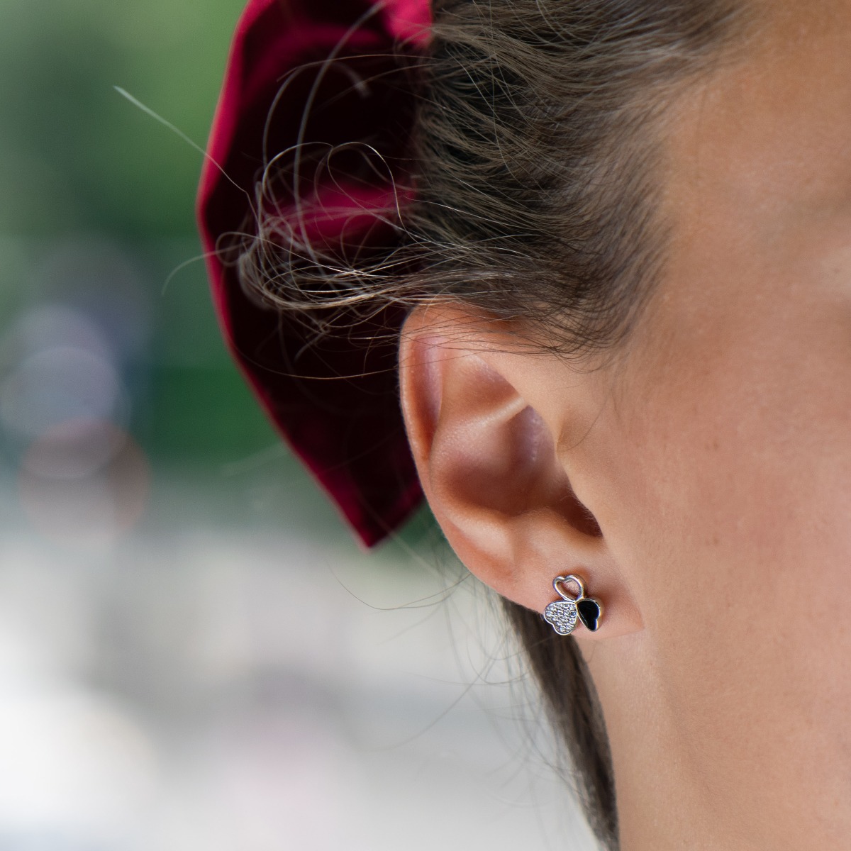 Delicate women's earrings in fine rhodium silver, with an interesting design layout of a charming clover, with black enamel petals and zircons. Featuring a three-leaf clover for luck and happiness, the earrings are a suitable gift for a girlfriend or belo