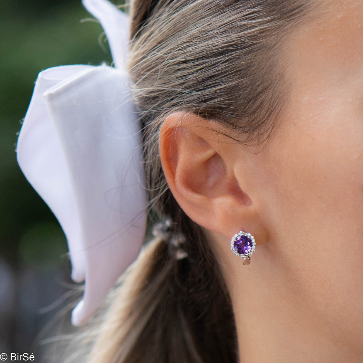 Magnificent earrings in delicate rhodium silver. An enchanted round-shaped amethyst rests in the center, surrounded by spectacular cubic zirconias. A beautiful jewel with a mysterious charm. For ladies who prefer unobtrusive jewelry.