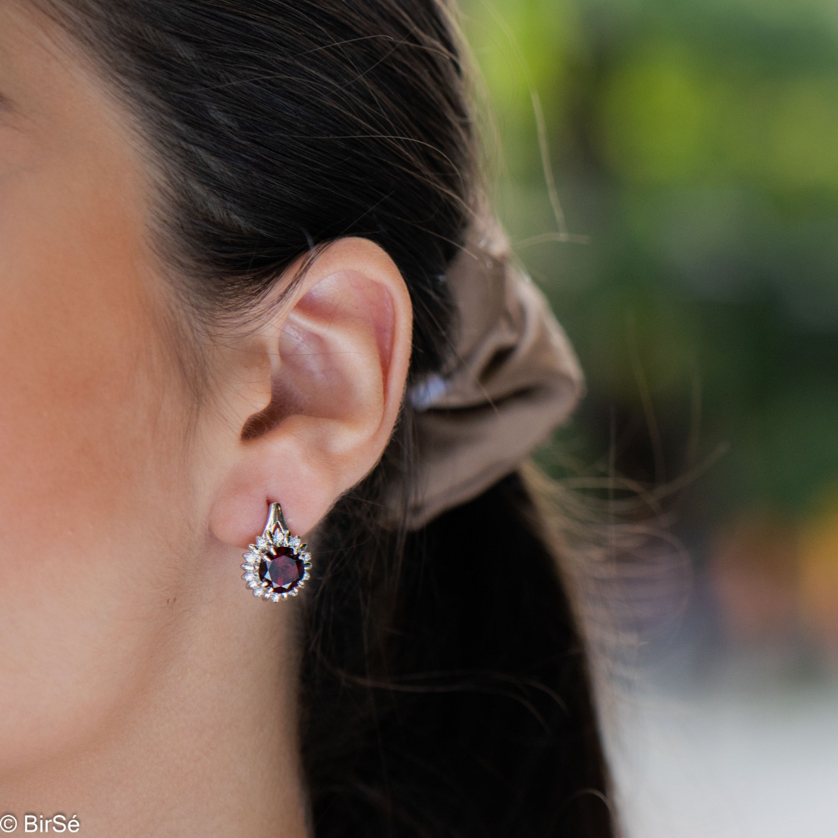 Extremely elegant ladies' earrings with English fastening and precise craftsmanship combining rhodium-plated silver with radiant natural garnet and sparkling zircons. They can be combined with a pendant and a ring of the same model.