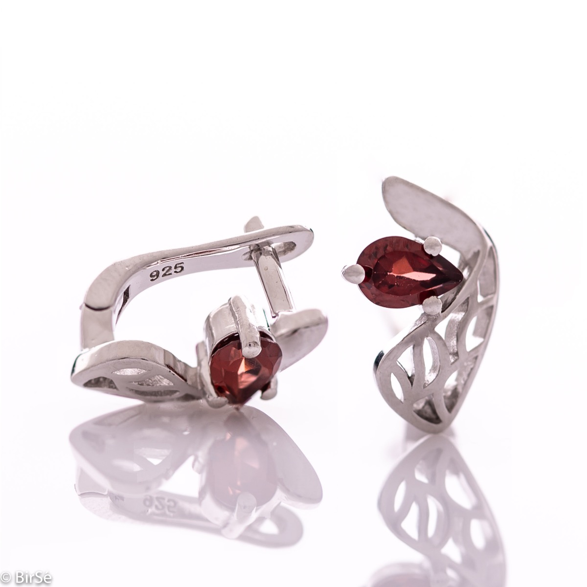 Gentle and spectacular ladies' earrings with English fastening and exquisite workmanship entirely of rhodium-plated silver combined with teardrop-shaped natural garnet. They can be combined with a pendant and a ring from the same set.