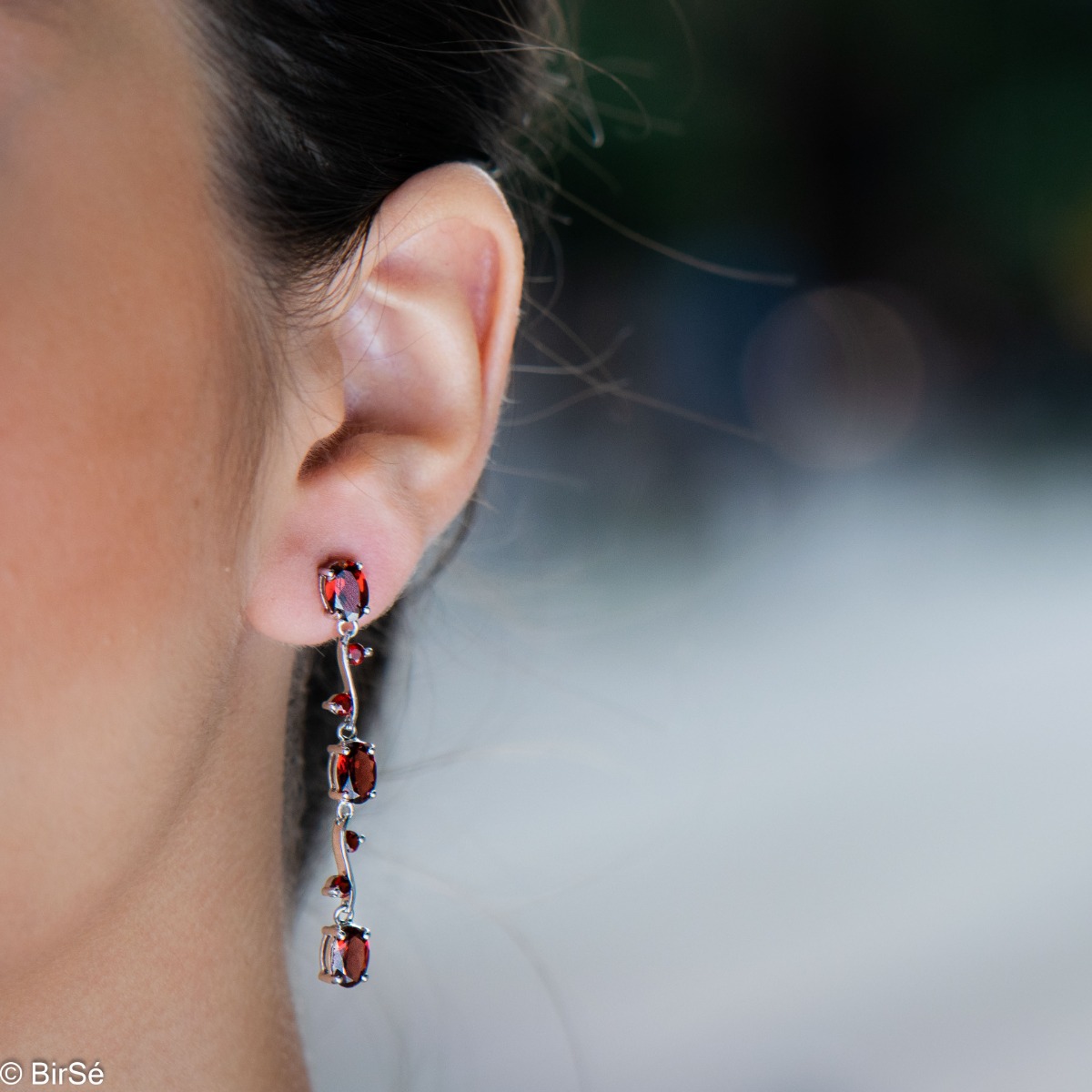 Extremely impressive dangling earrings with delicate workmanship combining numerous natural garnet stones with shiny rhodium silver.