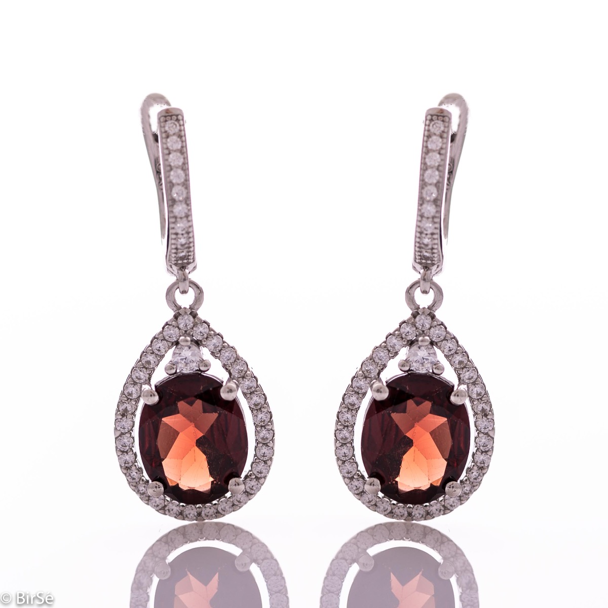 Elegant ladies' earrings with an English clasp and an impressive design combining delicate rhodium silver with a radiant natural garnet surrounded by sparkling zircons. They can be combined with a pendant and a ring of the same model.