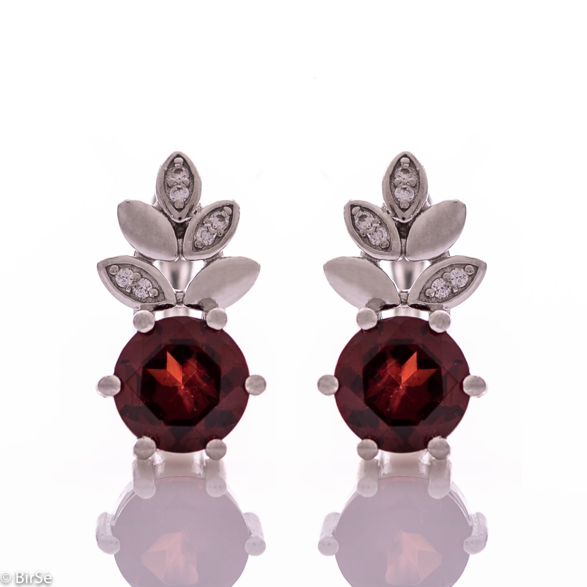 Delicate ladies' earrings with an English clasp and an exclusive design combining a radiant natural garnet surrounded by petals of zircons and made entirely of rhodium-plated silver. They can be combined with a pendant and a ring of the same model.