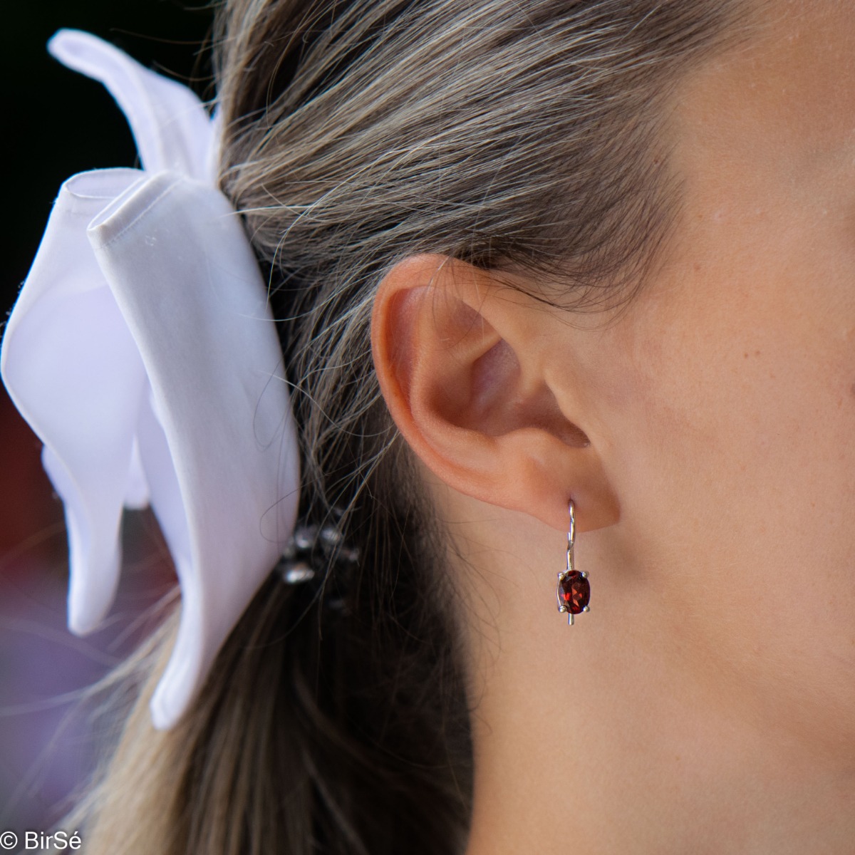 Delicate women's earrings with a clean and precise design combining shiny rhodium silver with radiant natural garnet.