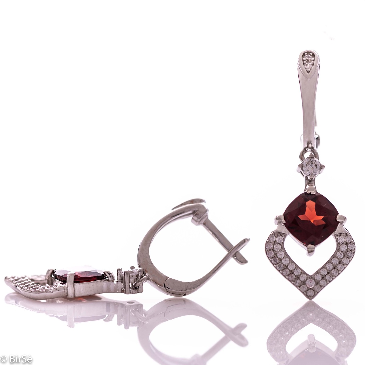 Dangling women's earrings with English clasp and exquisite craftsmanship combining delicate rhodium silver with radiant natural garnet and sparkling zircons. They can be combined with a ring and pendant of the same model.