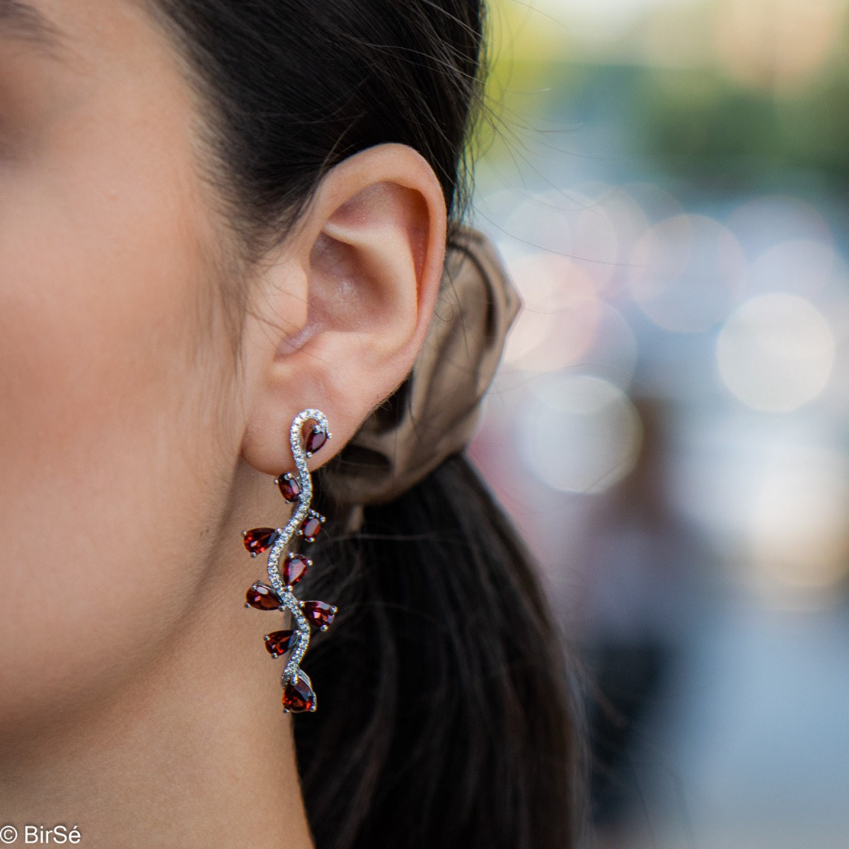 Dangling women's stud earrings with exquisite workmanship combining delicate rhodium silver with numerous natural garnet stones and sparkling zircons.