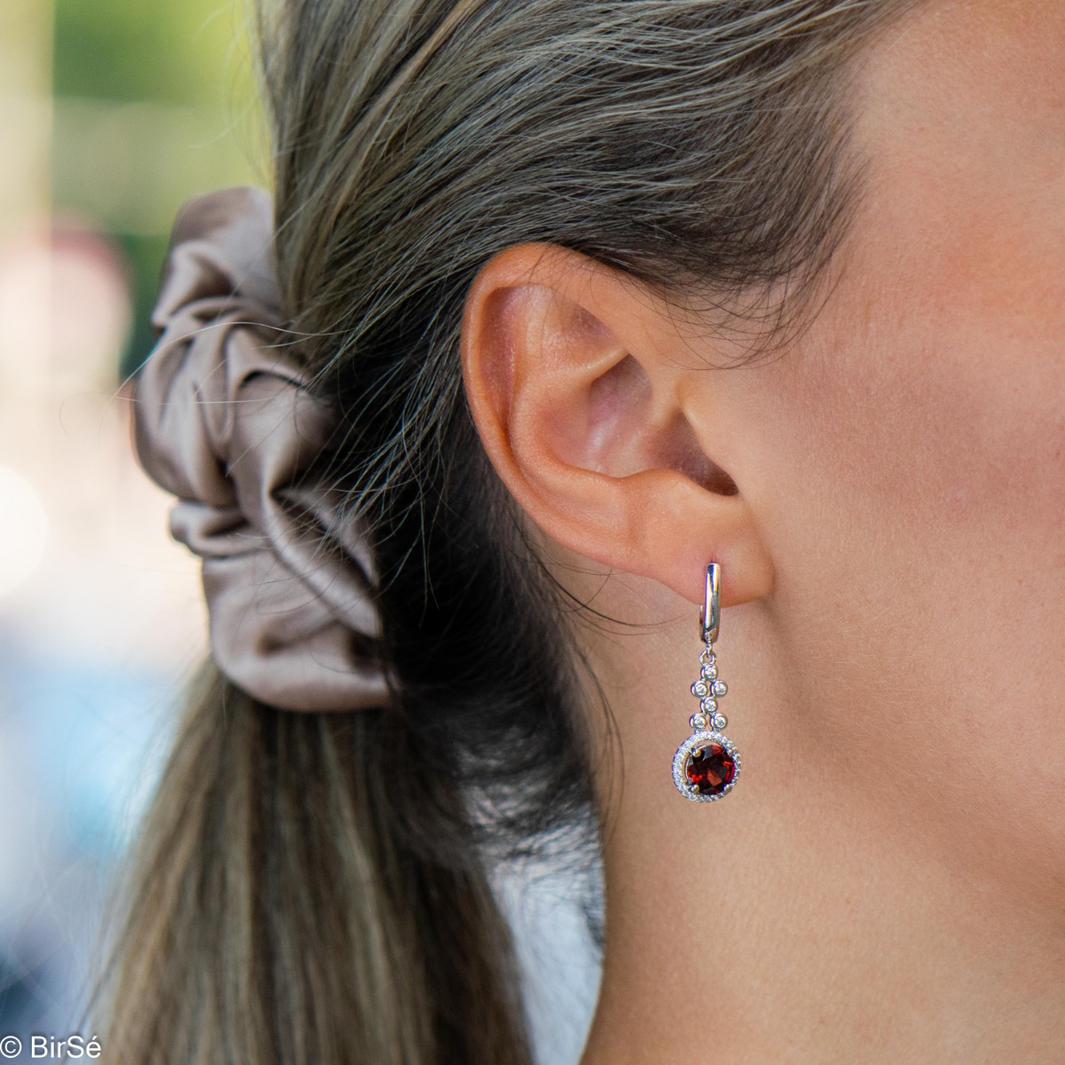 Women's dangle earrings with English clasp and precision craftsmanship entirely in rhodium-plated silver, combined with radiant natural garnet and sparkling zircons. They can be combined with a ring and pendant of the same model.