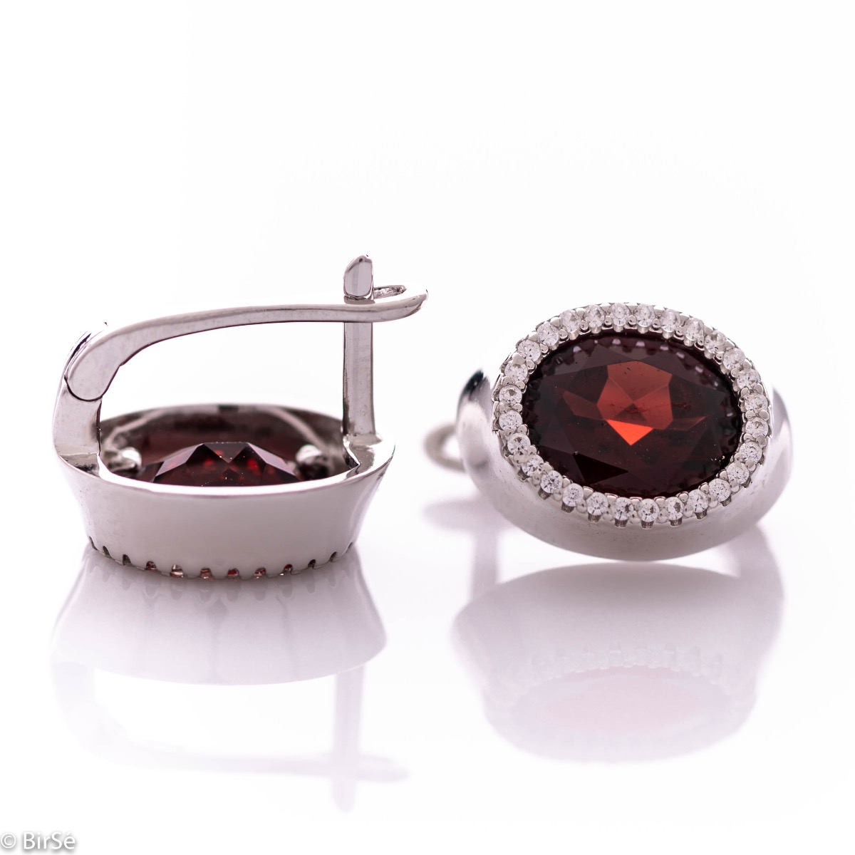 Elegant women's earrings with an English clasp and a classic design combining a radiant natural garnet surrounded by sparkling zircons with soft rhodium silver. They can be combined with a ring and pendant of the same model.