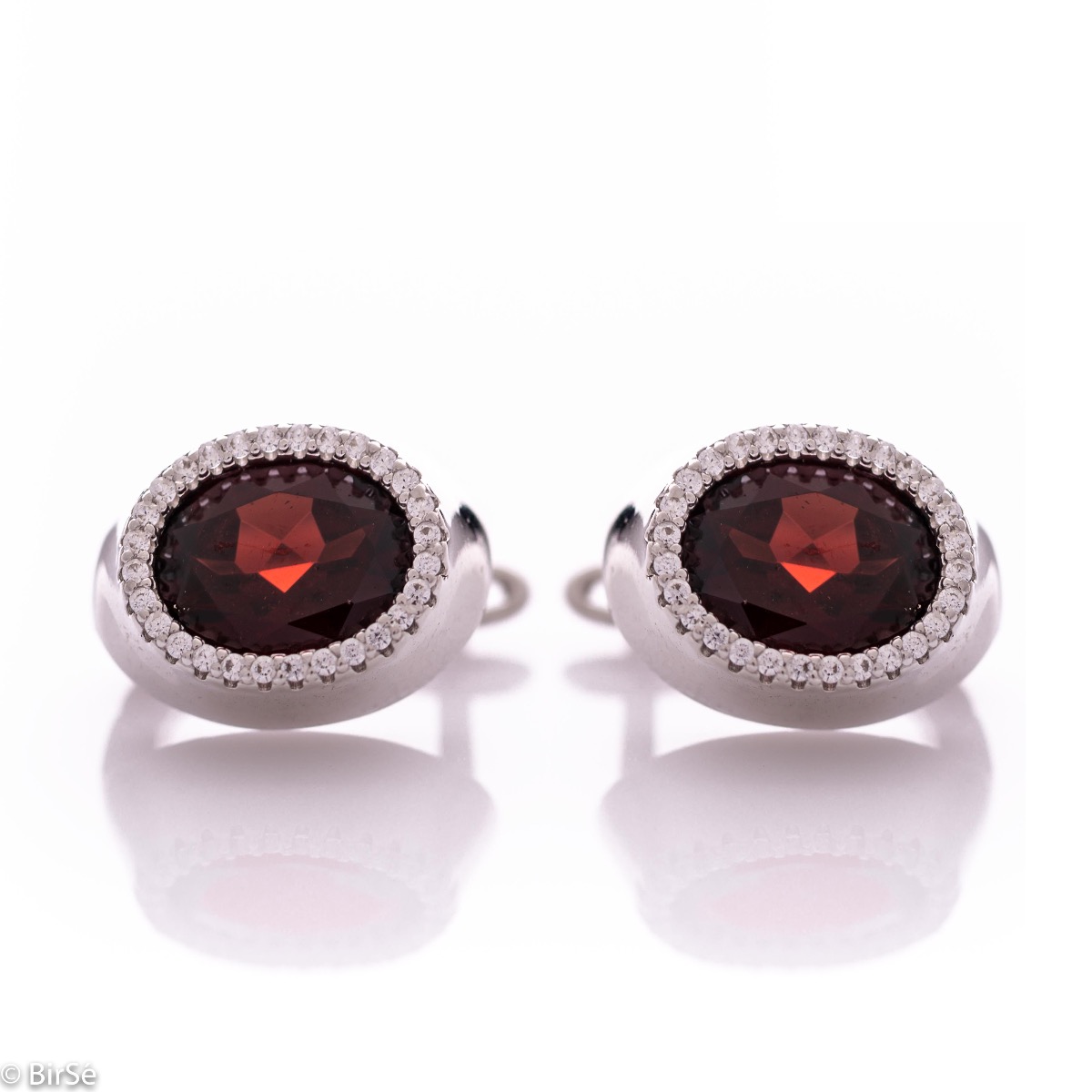 Elegant women's earrings with an English clasp and a classic design combining a radiant natural garnet surrounded by sparkling zircons with soft rhodium silver. They can be combined with a ring and pendant of the same model.