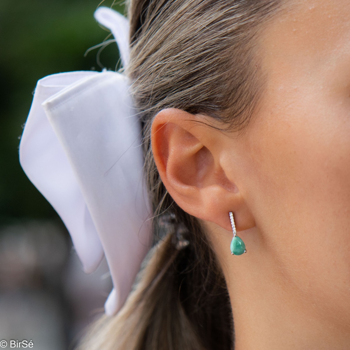 Exquisite women's earrings with a spectacular and radiant combination of a natural emerald stone with fine shiny zircons and delicate workmanship entirely of rhodium-plated silver.