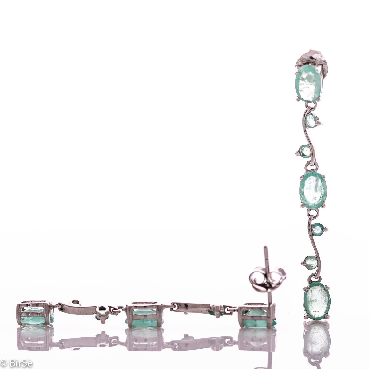 Extremely impressive dangling earrings with delicate workmanship combining numerous natural emerald stones with shiny rhodium silver.