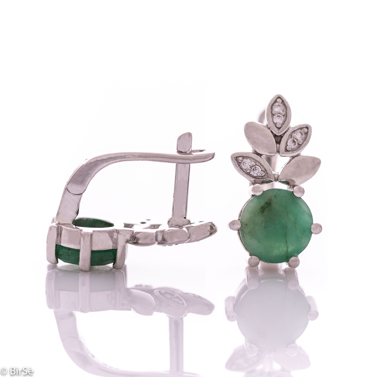 Delicate ladies' earrings with English clasp and an exclusive design combining a radiant natural emerald surrounded by cubic zirconia petals and made entirely of rhodium-plated silver. They can be combined with a pendant and a ring of the same model.