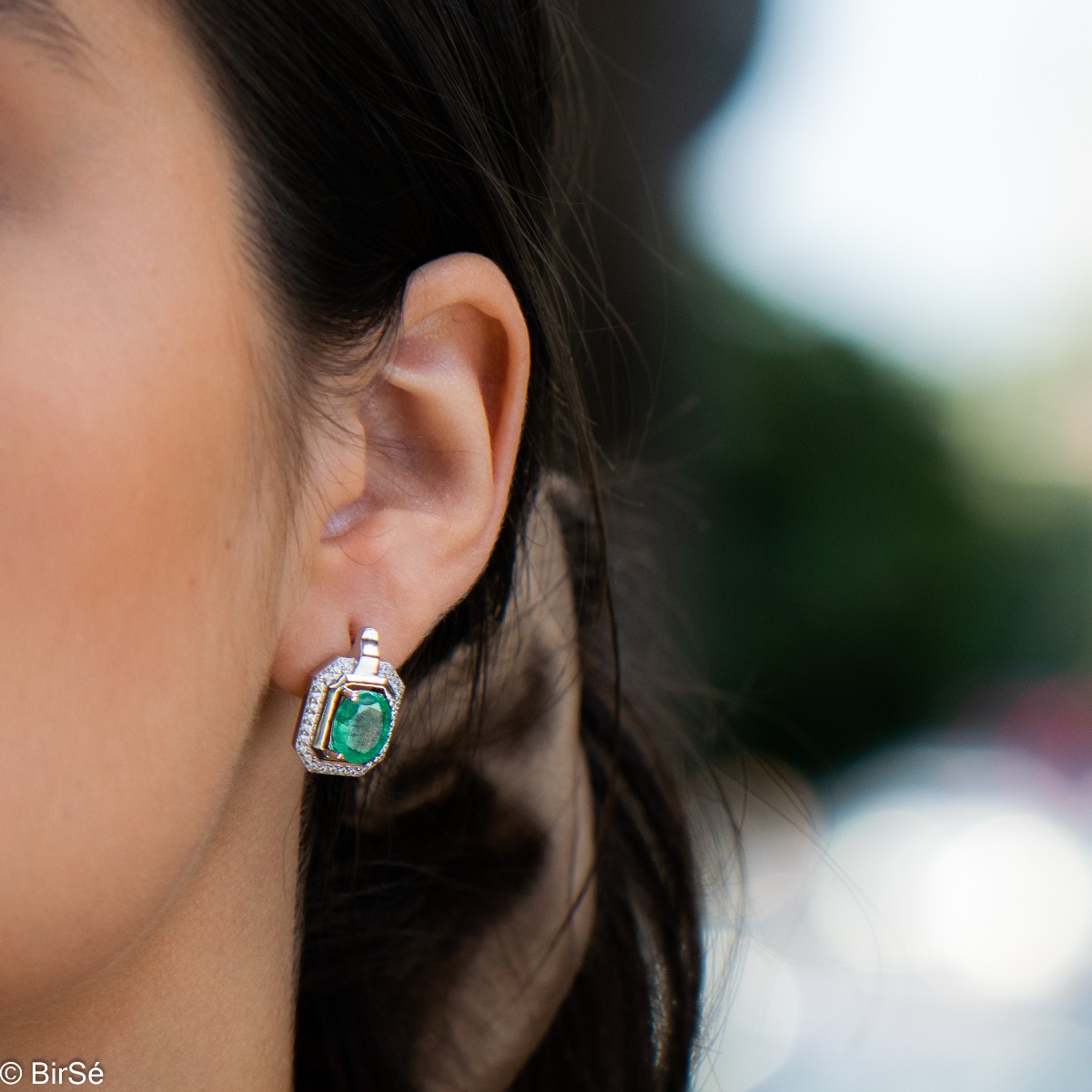 Elegant women's earrings with English clasp and precision craftsmanship entirely of rhodium-plated silver, combined with a radiant natural emerald and sparkling zircons. They can be combined with a ring and pendant of the same model.