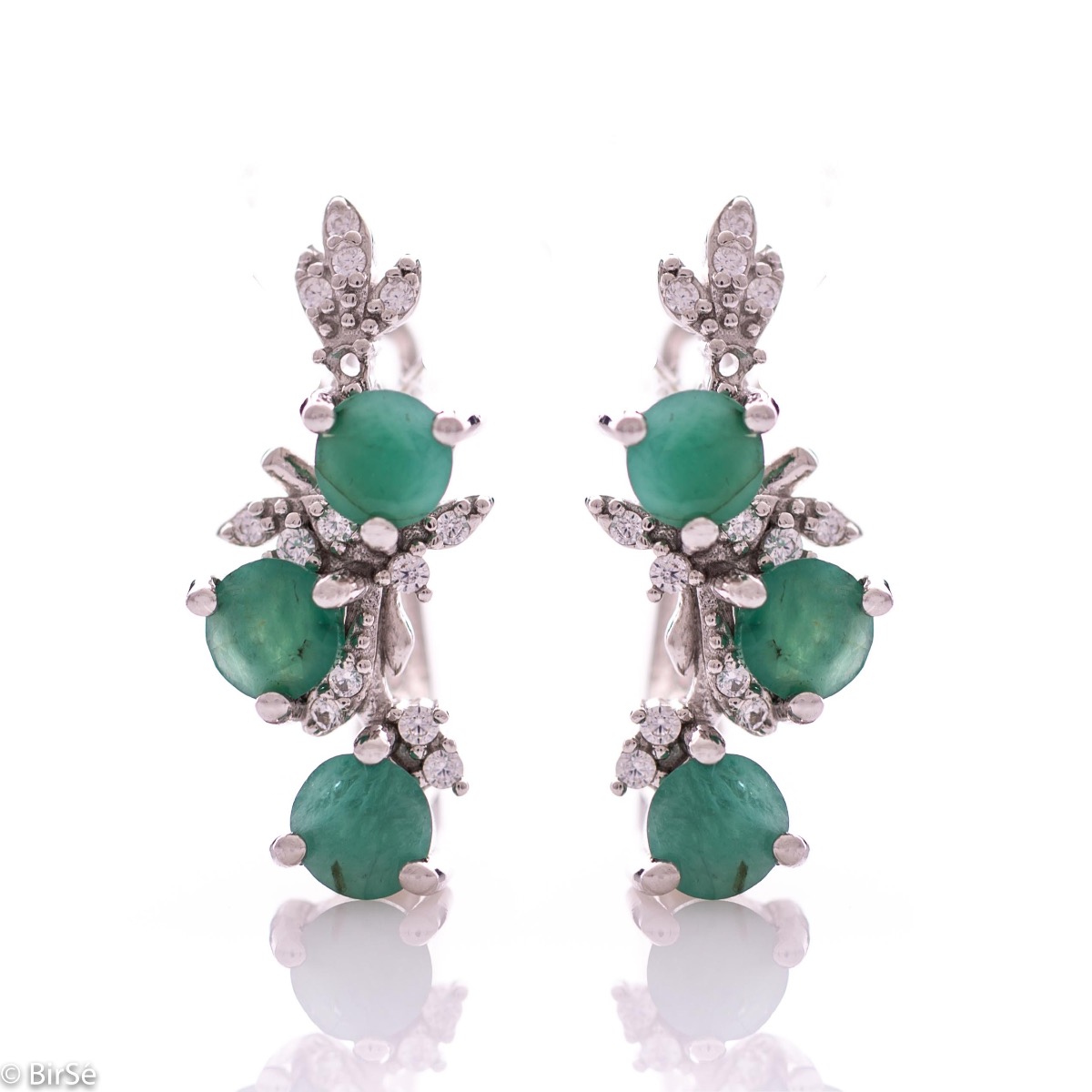 Exclusive women's earrings with English clasp and delicate design, combining craftsmanship entirely from rhodium-plated silver, complemented by natural emeralds and zircons. They can be combined with a pendant and a ring of the same model.