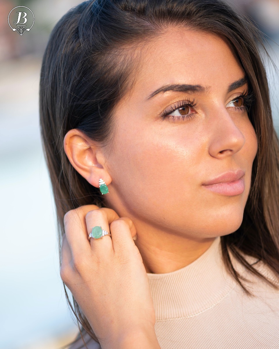 Exquisite ladies' earrings with English clasp and delicate craftsmanship entirely in rhodium-plated silver, combined with a radiant natural emerald and sparkling zircons. They can be combined with a ring and pendant of the same model.