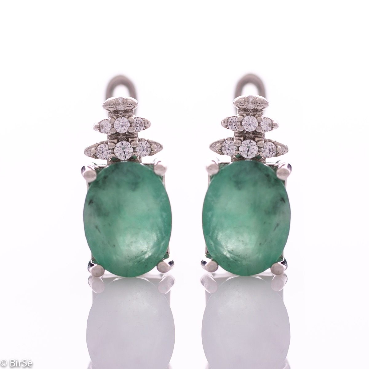 Exquisite ladies' earrings with English clasp and delicate craftsmanship entirely in rhodium-plated silver, combined with a radiant natural emerald and sparkling zircons. They can be combined with a ring and pendant of the same model.