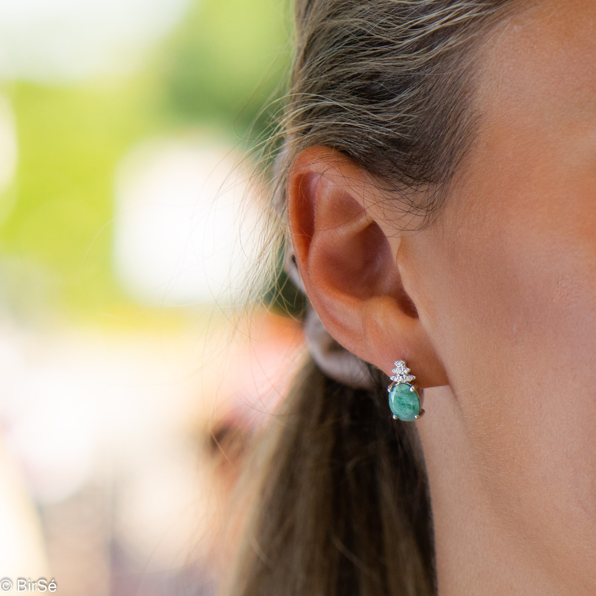 Exquisite ladies' earrings with English clasp and delicate craftsmanship entirely in rhodium-plated silver, combined with a radiant natural emerald and sparkling zircons. They can be combined with a ring and pendant of the same model.