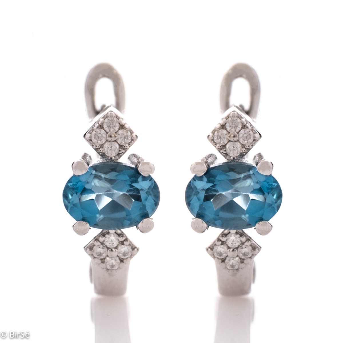 Exclusive women's earrings with unique craftsmanship and a gentle combination of a natural and radiant London topaz stone with glittering zircons and exquisite rhodium-plated silver.