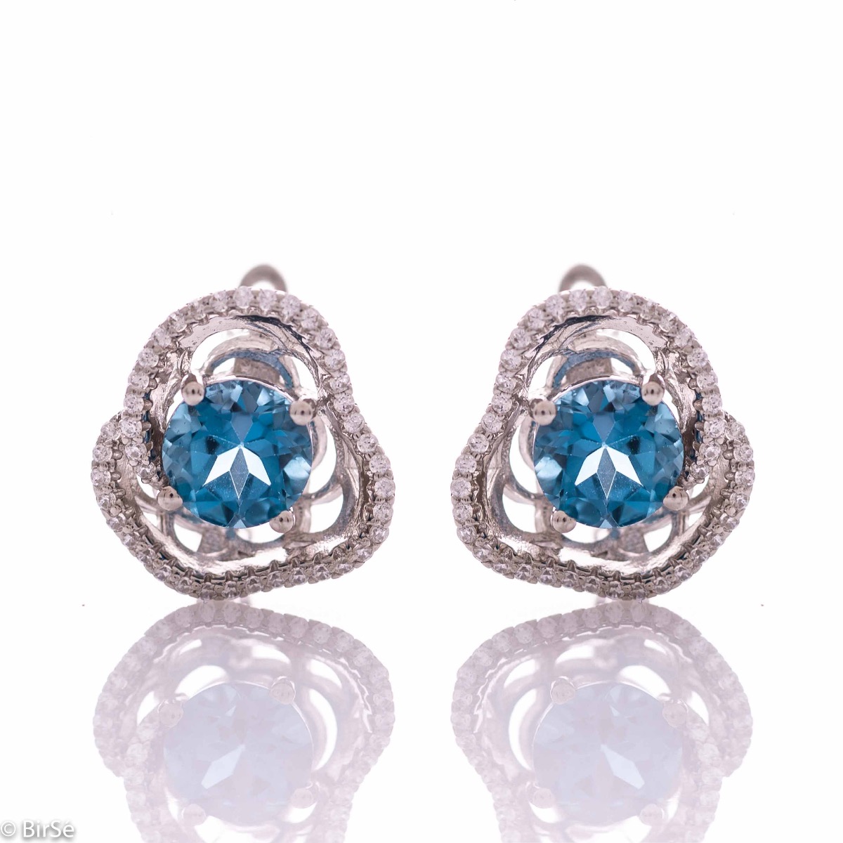 Elegant women's earrings with English clasp and exquisite workmanship entirely in rhodium-plated silver complemented by the glow of natural London topaz and sparkling zircons. They can be combined with a ring and pendant of the same model.