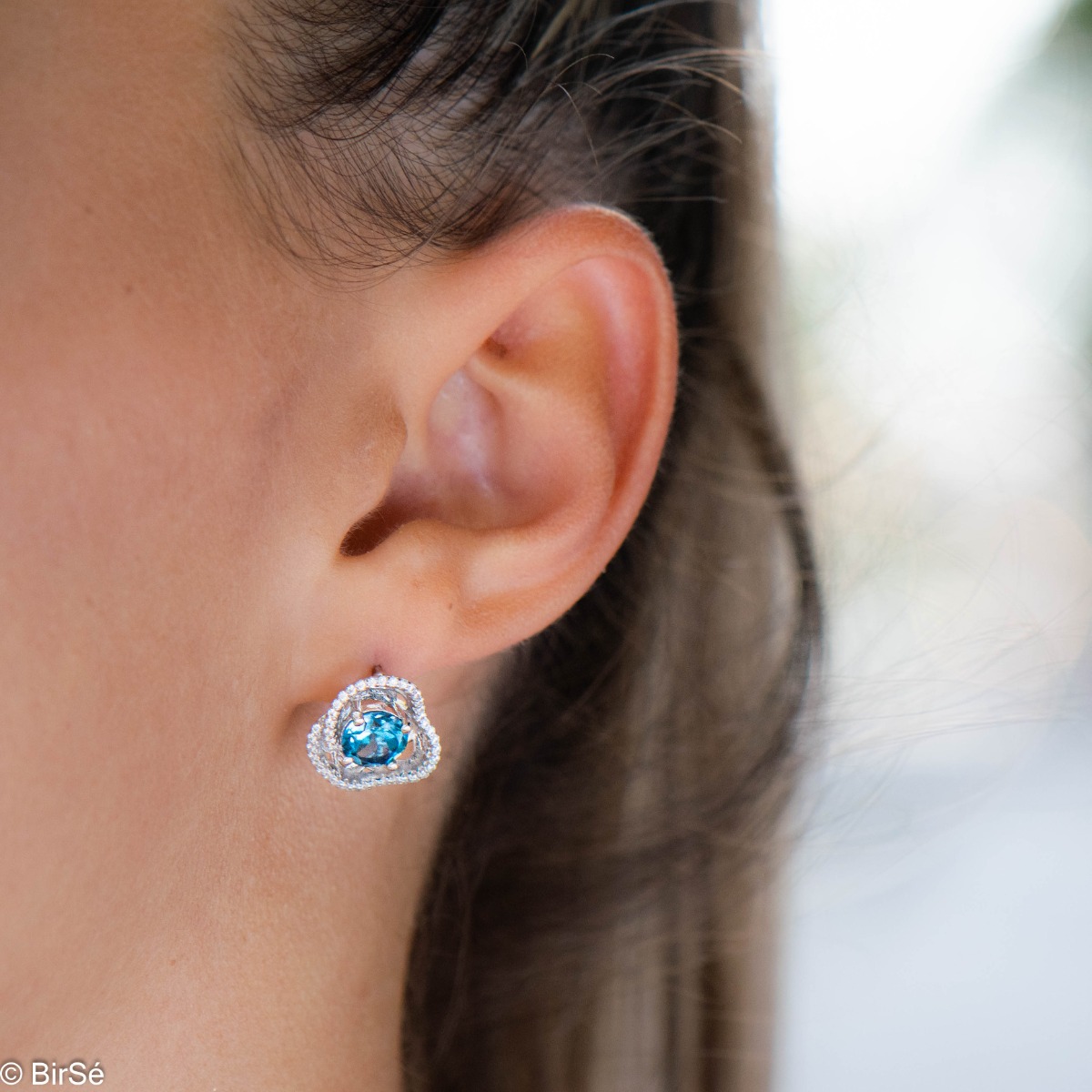 Elegant women's earrings with English clasp and exquisite workmanship entirely in rhodium-plated silver complemented by the glow of natural London topaz and sparkling zircons. They can be combined with a ring and pendant of the same model.