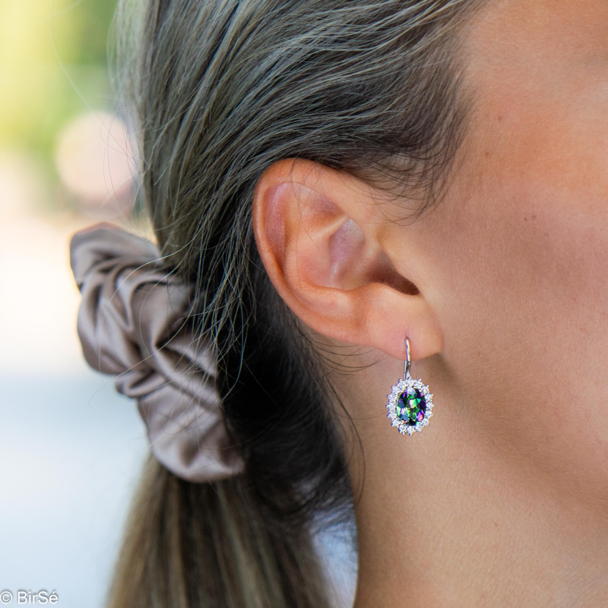 Captivating women's earrings with magnetic Mystic Topaz carefully surrounded by sparkling zircons. The earrings are made of rhodium silver with a comfortable willow clasp. A wonderful gift for the beloved wife, mother or girlfriend.