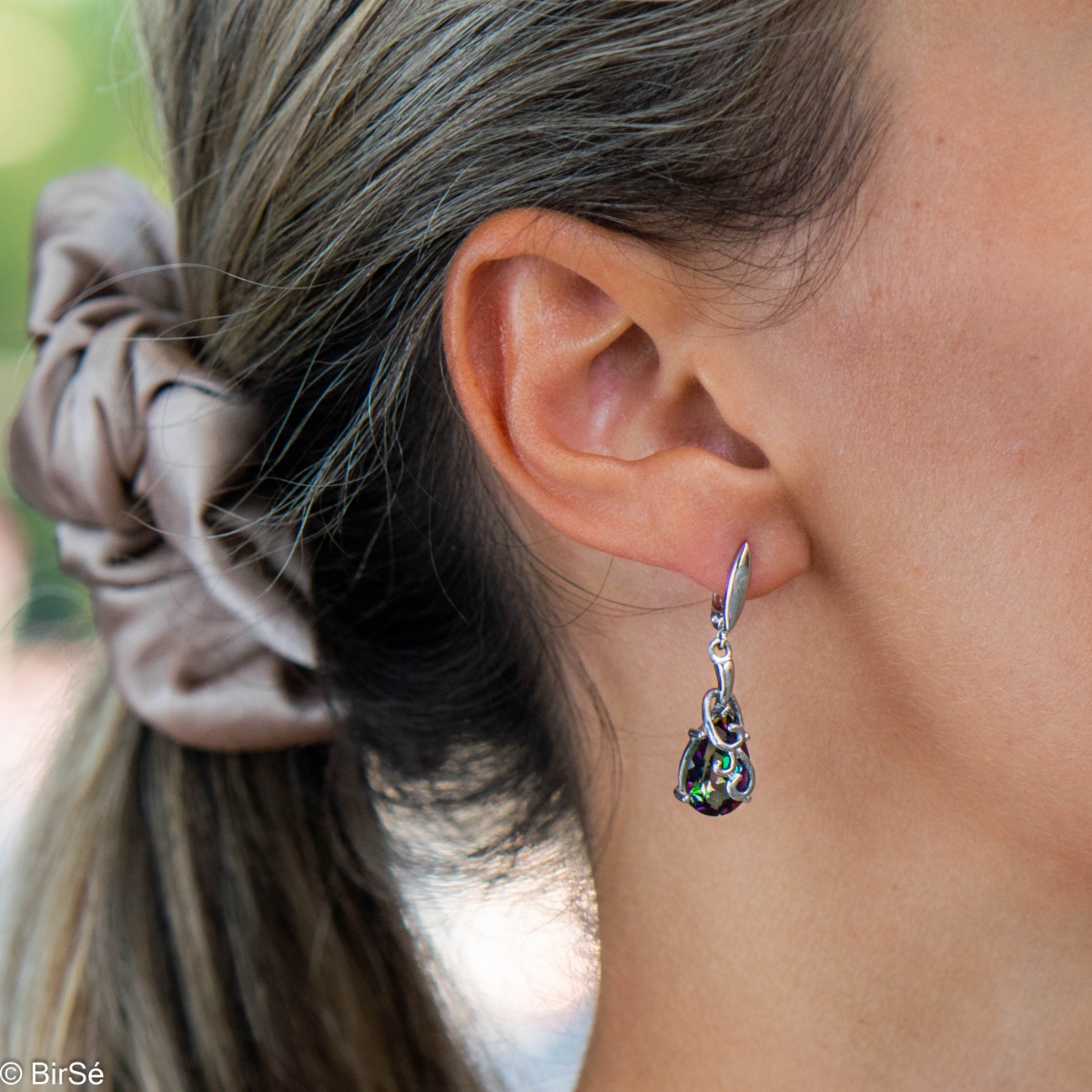 Women's dangling earrings with a unique design and exquisite workmanship entirely of rhodium-plated silver combined with a drop-shaped natural mystic topaz.