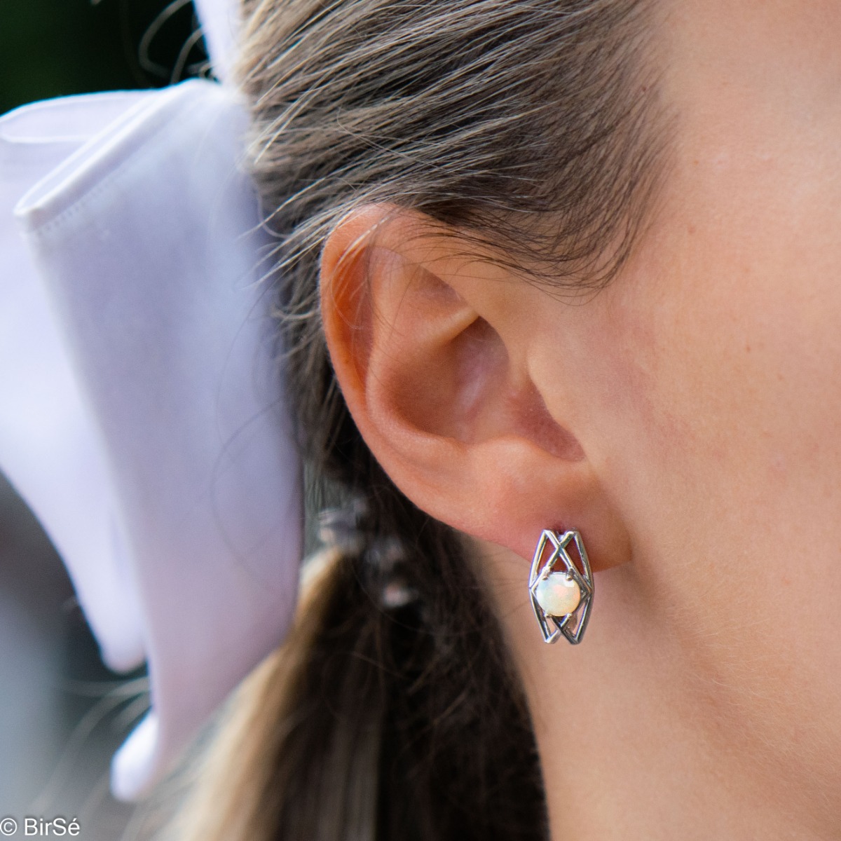 Enjoy the delicate beauty of natural opal embedded in two stylish earrings. It is made of rhodium-plated silver, and the fastening is English. For a complete look, you can also add a ring from the collection.