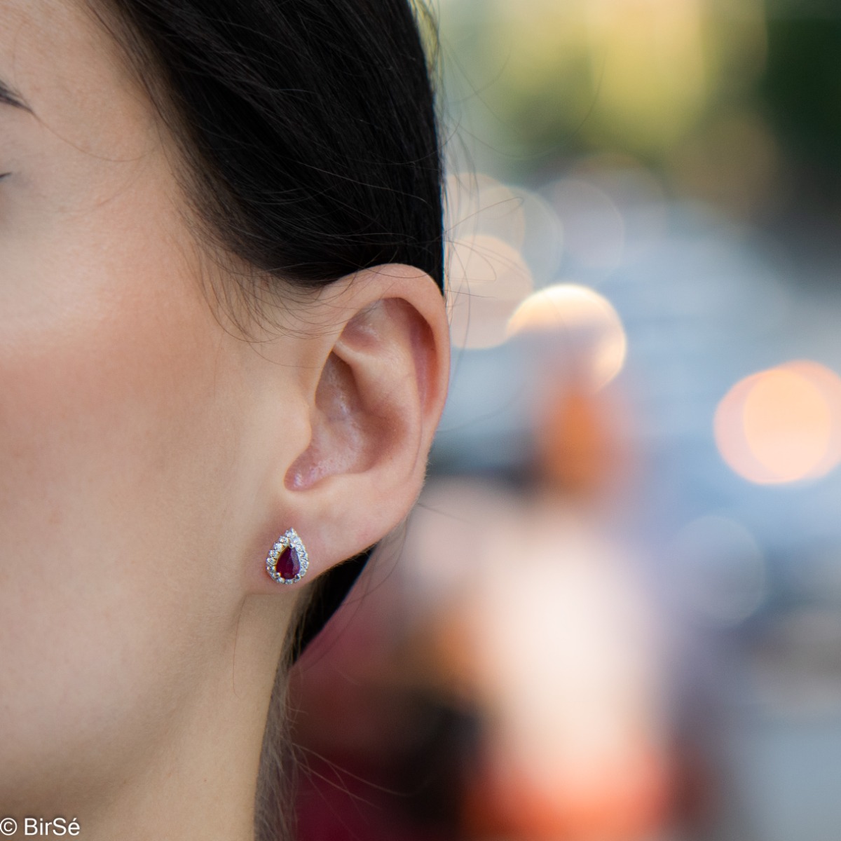 Radiant stud earrings delicately crafted in a teardrop shape and finely rhodium-plated sterling silver, complemented by exquisite natural rubies and sparkling zircons.