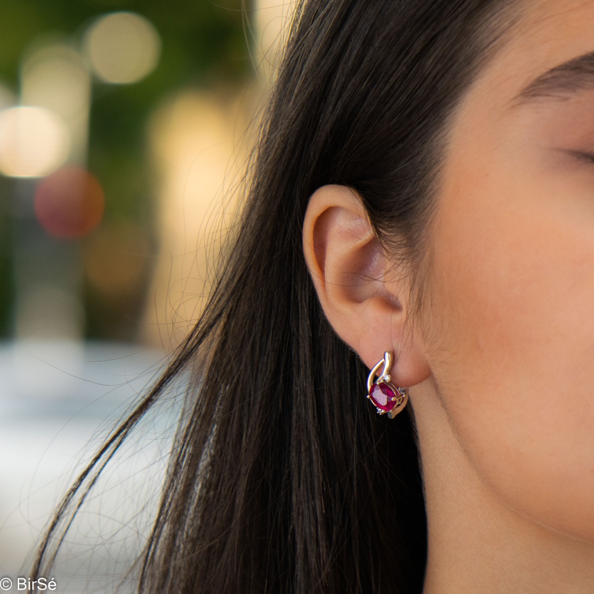 Delicate and elegant earrings in fine rhodium silver, charmingly intertwined with radiant natural ruby ​​and zircons.