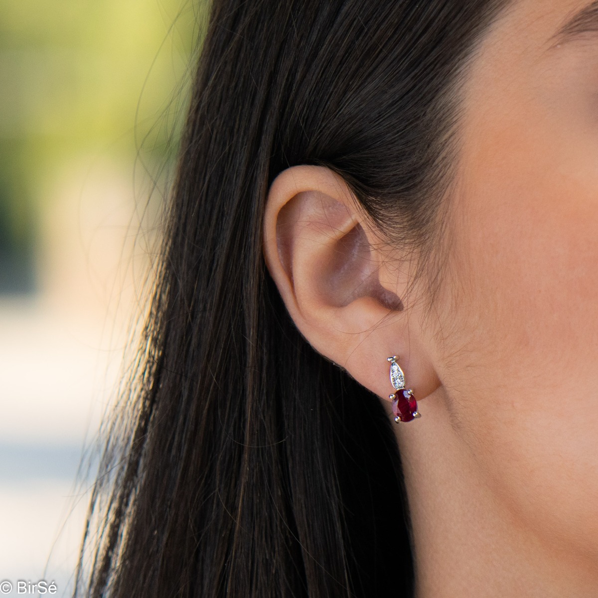 Dazzling women's earrings with English clasp and a delicate combination of a radiant natural ruby, finely crafted in rhodium-plated silver, complemented by beautiful zircons. In an exclusive ring and pendant set.