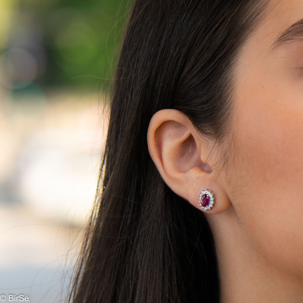 Delicate and radiant women's stud earrings with exquisite workmanship combining a unique natural ruby, surrounded by sparkling zircons, with rhodium-plated silver. They can be combined with a ring, necklace and bracelet of the same model.