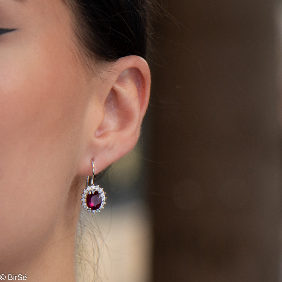 Exclusive women's earrings with exquisite craftsmanship combining delicate rhodium silver with a radiant natural ruby ​​surrounded by sparkling zircons.