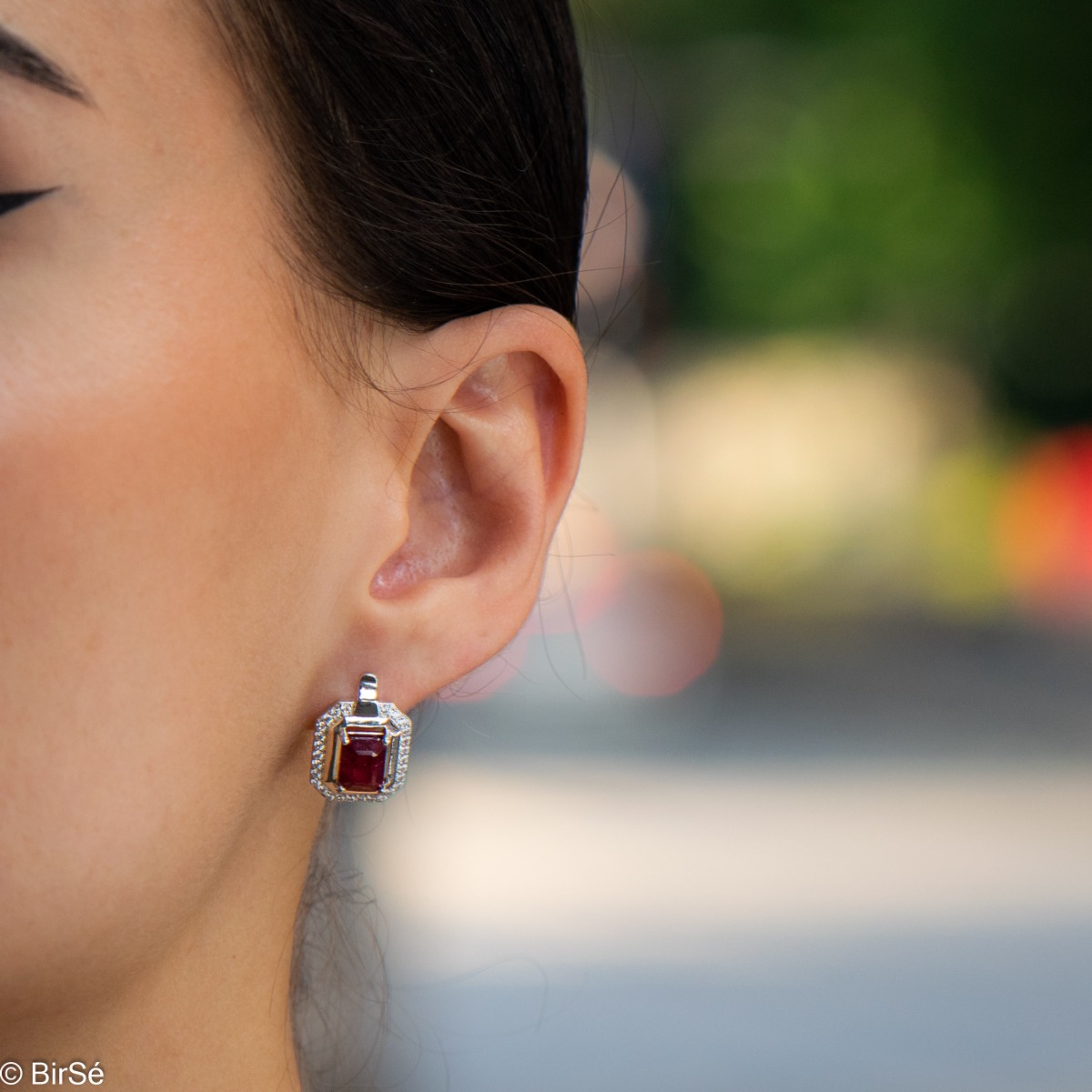 Elegant women's earrings with English clasp and precision craftsmanship entirely of rhodium-plated silver, combined with a radiant natural ruby ​​and sparkling zircons. They can be combined with a ring and pendant of the same model.