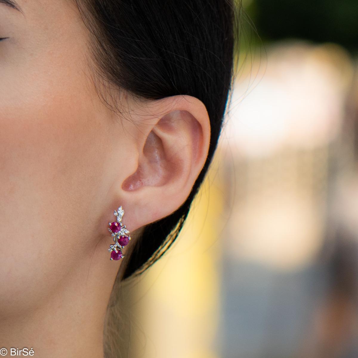 Exclusive women's earrings with English clasp and delicate design, combining craftsmanship entirely from rhodium-plated silver, complemented by natural rubies and zircons. They can be combined with a pendant and a ring of the same model.