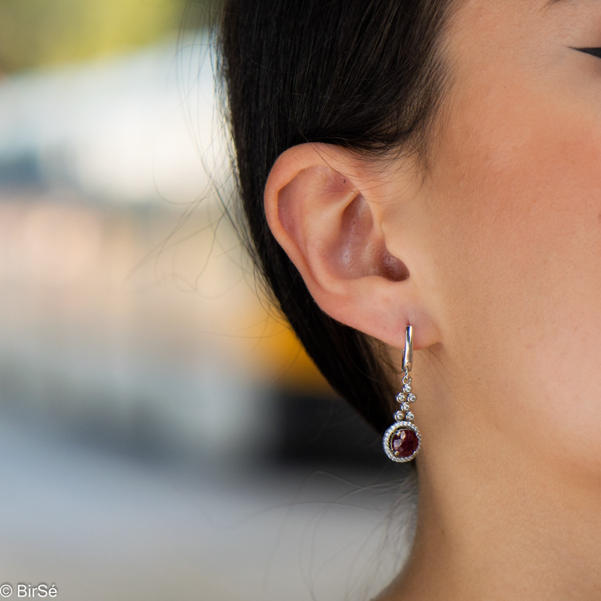 Women's dangling earrings with English clasp and precision craftsmanship entirely in rhodium-plated silver, combined with a radiant natural ruby ​​and sparkling zircons. They can be combined with a ring and pendant of the same model.