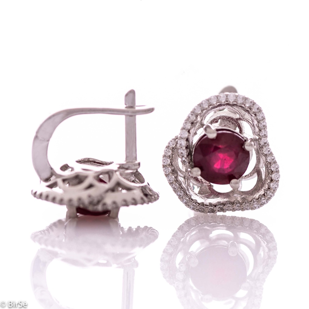 Elegant women's earrings with English clasp and exquisite workmanship entirely of rhodium-plated silver complemented by the glow of natural ruby ​​and sparkling zircons. They can be combined with a ring and pendant of the same model.