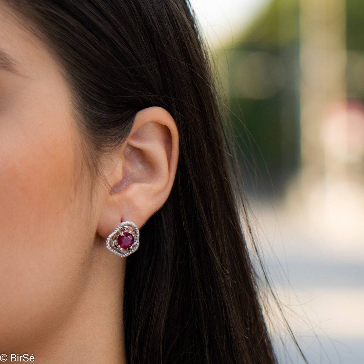 Elegant women's earrings with English clasp and exquisite workmanship entirely of rhodium-plated silver complemented by the glow of natural ruby ​​and sparkling zircons. They can be combined with a ring and pendant of the same model.