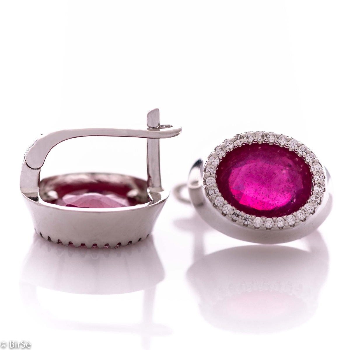 Elegant women's earrings with an English clasp and a classic design combining a radiant natural ruby ​​surrounded by sparkling zircons with delicate rhodium silver. They can be combined with a ring and pendant of the same model.