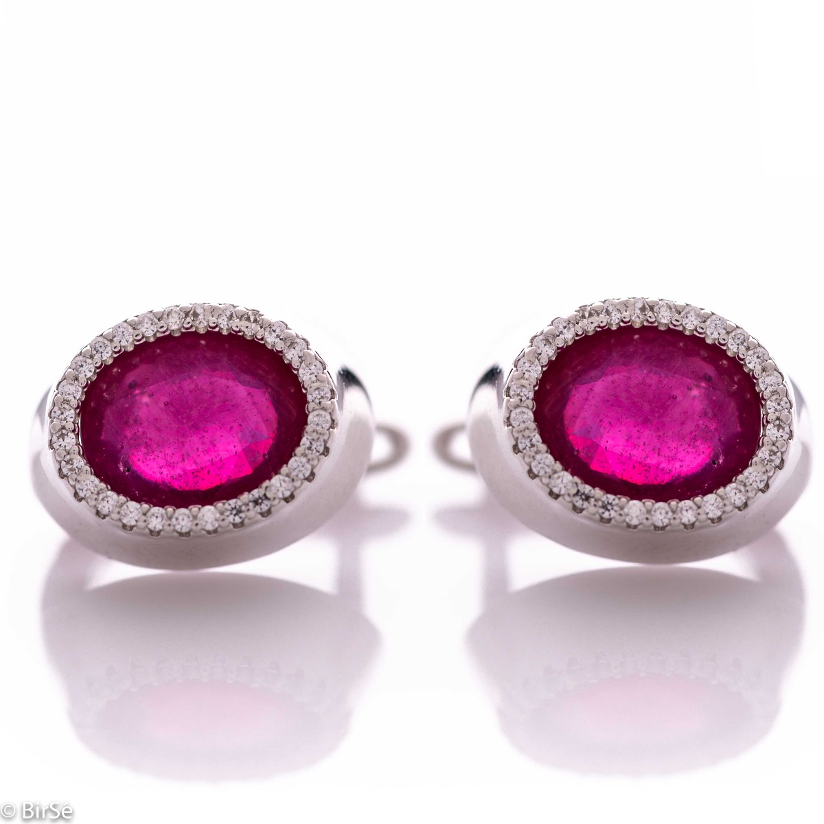 Elegant women's earrings with an English clasp and a classic design combining a radiant natural ruby ​​surrounded by sparkling zircons with delicate rhodium silver. They can be combined with a ring and pendant of the same model.