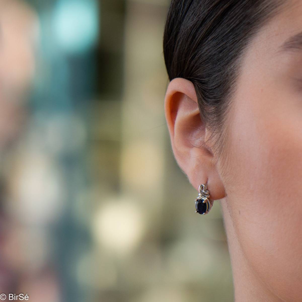 Elegant women's earrings with English clasp and refined craftsmanship entirely in rhodium-plated silver, complemented by a radiant natural sapphire stone.