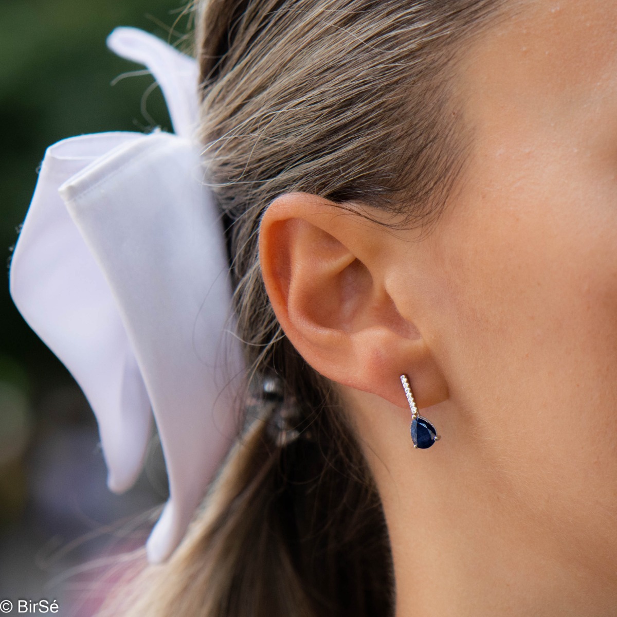 Get an elegant style with rhodium-plated sterling silver and drop-shaped natural sapphire earrings. The added sparkling zircons add extra charm to the jewelry.