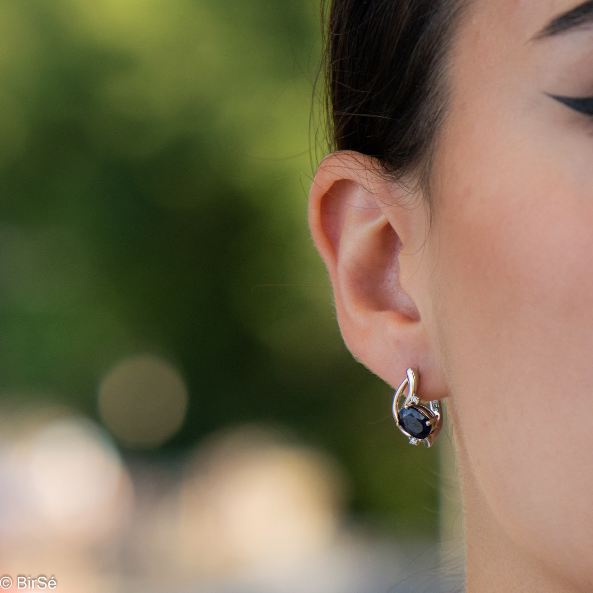 Elegant silver earrings with a gentle glow of natural sapphire and sparkling zircons.