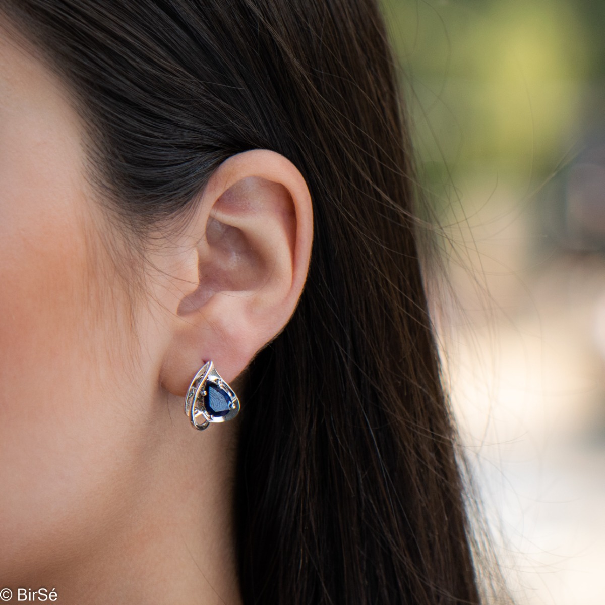 Elegant women's earrings in a modern arrangement of geometric elements and shapes, made of a stylish combination of rhodium-plated soft silver and radiant natural sapphire. Part of an exclusive set with a beautiful ring and pendant.